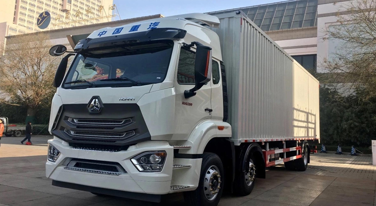 Um HOWO-NX branco estacionado perto da comunidade